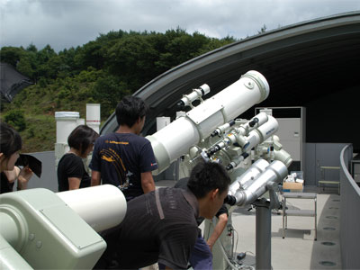 観察会の様子を写した写真。小型望遠鏡で来館者が星を見ているところ。