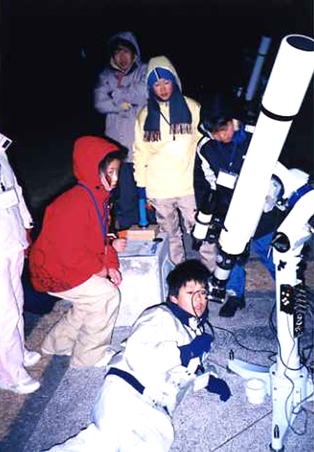 子どもたちが望遠鏡を操作する様子の写真