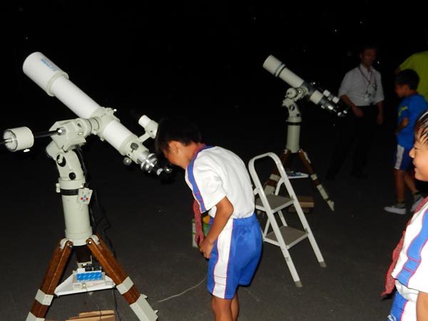 小型の望遠鏡で星を観察している写真